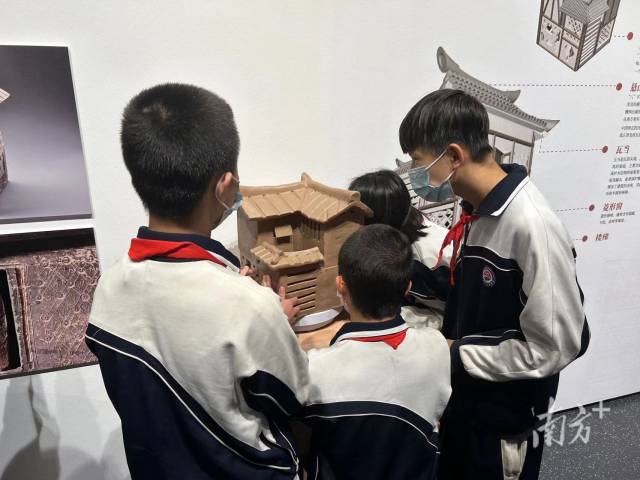 广州市启明学校学生在现场用手触摸模型展品。