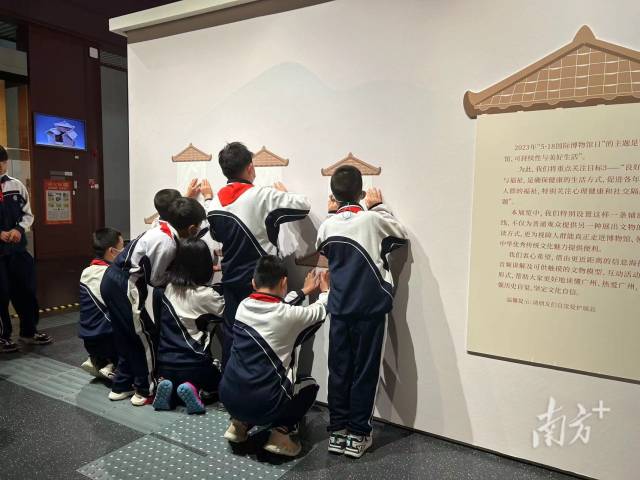 广州市启明学校学生在现场触读盲文展板。