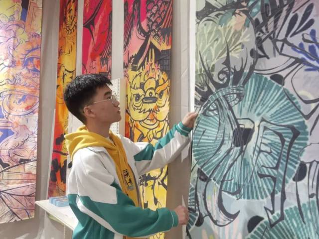 佛山市华材职业技术学校学生郑嘉俊和他的醒狮主题画作。